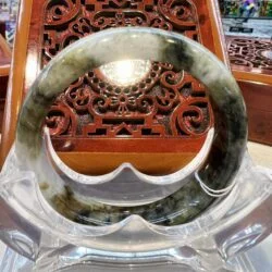 A large green and white jade bangle sitting on top of a table.