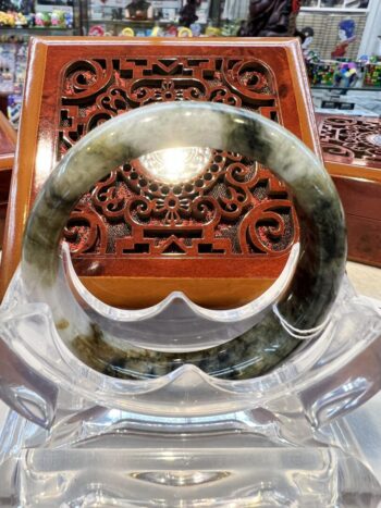 A large green and white jade bangle sitting on top of a table.