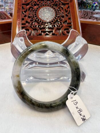 A green and white bangle sitting on top of a table.