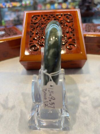 A green stone is sitting in front of a wooden box.