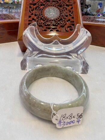 A large green jade bangle sitting on top of a table.