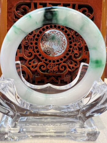 A green and white circular glass plate on top of a table.