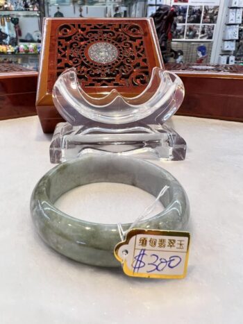 A green jade bangle sitting on top of a table.