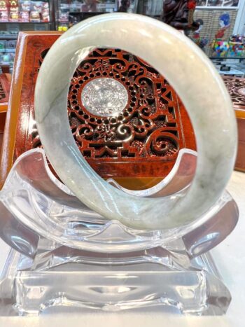 A large white bangle sitting on top of a clear glass object.