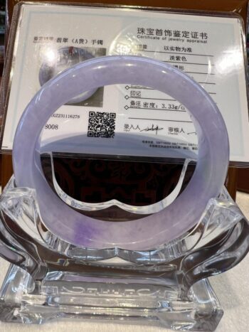 A purple bracelet sitting on top of a glass table.