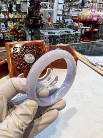 A person holding an open white bangle.