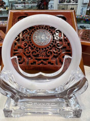 A white glass plate with a wooden carving.