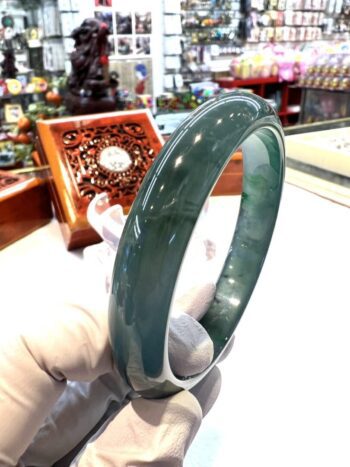 A person holding onto a green bangle