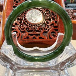 A green jade bangle sitting on top of a table.