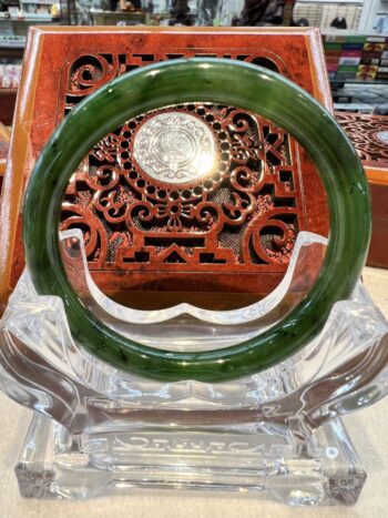 A green jade bangle sitting on top of a table.