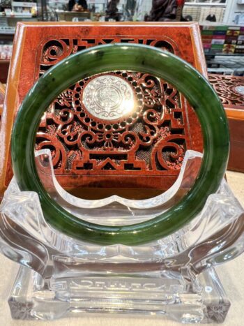 A green jade bangle sitting on top of a table.