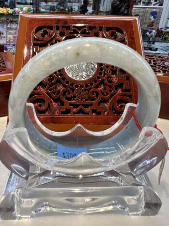 A close up of an asian chair with a glass table in the background