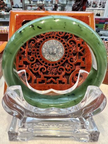 A green glass ring sitting on top of a clear chair.