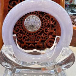 A white glass clock sitting on top of a clear stand.