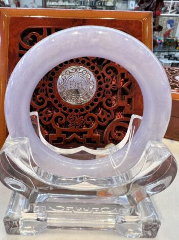 A white glass clock sitting on top of a clear stand.