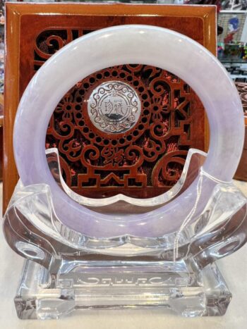 A white and clear glass sculpture with a clock in the background.