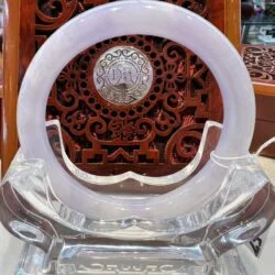 A white circular clock sitting on top of a wooden table.