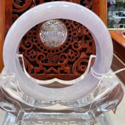 A white plastic chair with a wooden carving in the background.