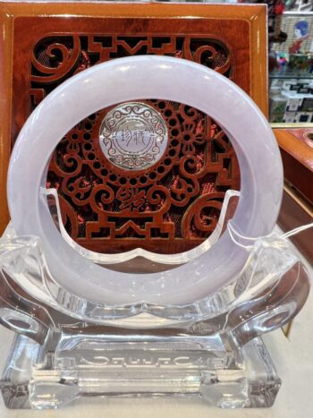 A white plastic chair with a wooden carving in the background.