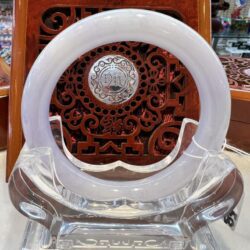 A white clock sitting on top of a glass table.