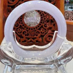 A white circular glass plate sitting on top of a clear chair.