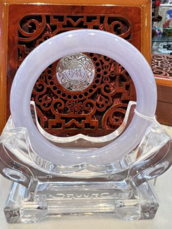 A white circular glass plate sitting on top of a clear chair.