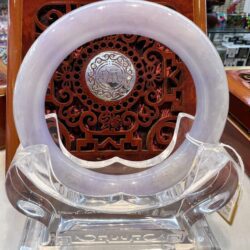 A white circular clock sitting on top of a clear chair.