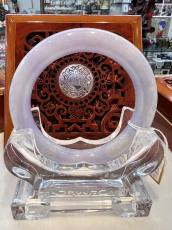 A white circular clock sitting on top of a clear chair.