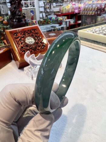 A person holding onto a green bangle