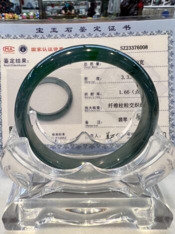 A glass bangle is sitting on top of a certificate.