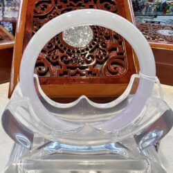 A clear plastic chair with an ornate wooden table in the background.