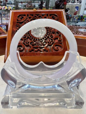 A clear plastic chair with an ornate wooden table in the background.