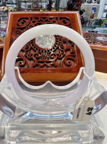 A white plastic object sitting on top of a wooden chair.