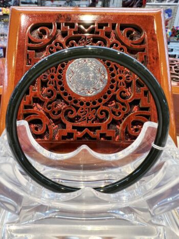 A black and white ring sitting on top of a wooden chair.