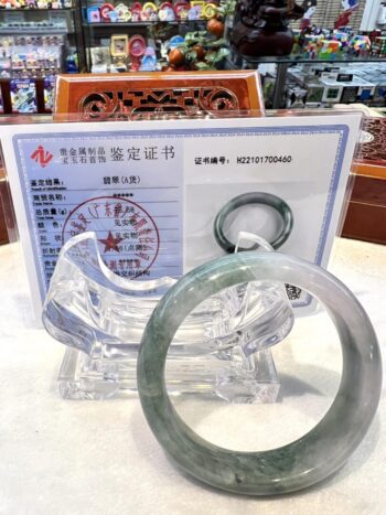 A green jade bangle sitting on top of a table.