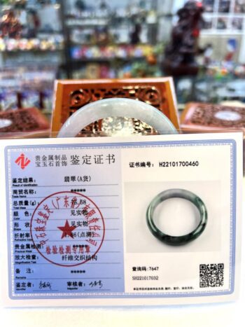 A person 's passport and ring with chinese writing on it.