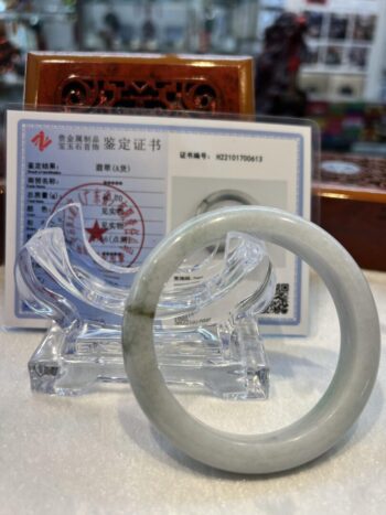 A white jade bangle sitting on top of a table.