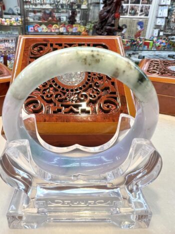 A large green and white jade bangle sitting on top of a table.