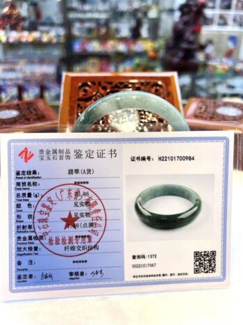 A green jade ring is sitting on the table.