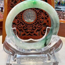 A green and white ring sitting on top of a glass table.