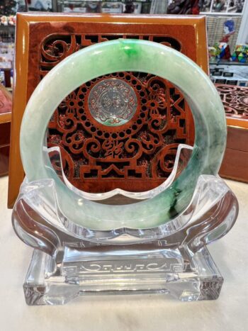 A green and white ring sitting on top of a glass table.