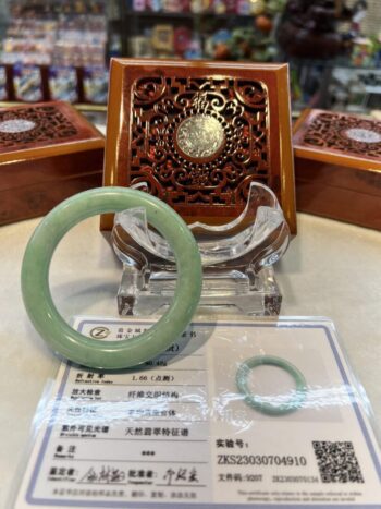 A green jade bangle sitting on top of a table.