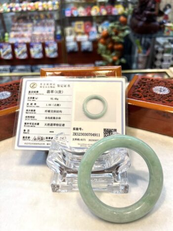 A green jade ring sitting on top of a table.