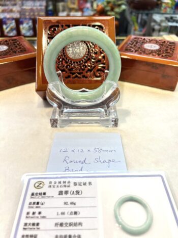 A green jade ring sitting on top of a table.