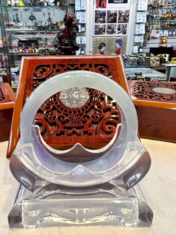 A display of an asian style carved wood and glass object.