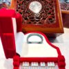 A red piano and wooden box on the floor.
