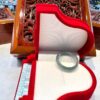 A glass ring sits in the middle of a red piano.