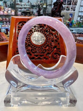 A purple bracelet sitting on top of a glass display.