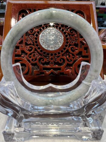 A large circular mirror with carved wood and glass.