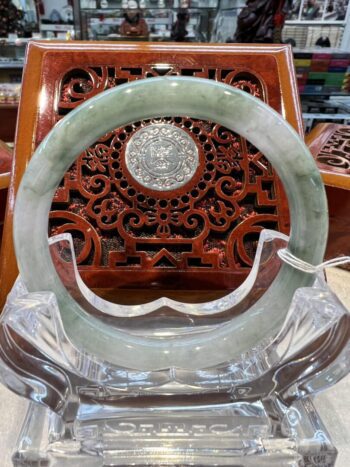 A large green jade bangle sitting on top of a table.